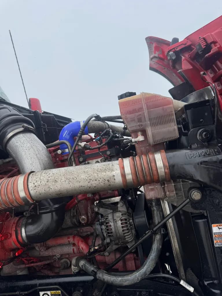 PACCAR engine compartment with coolant reservoir and alternator during diagnostics
