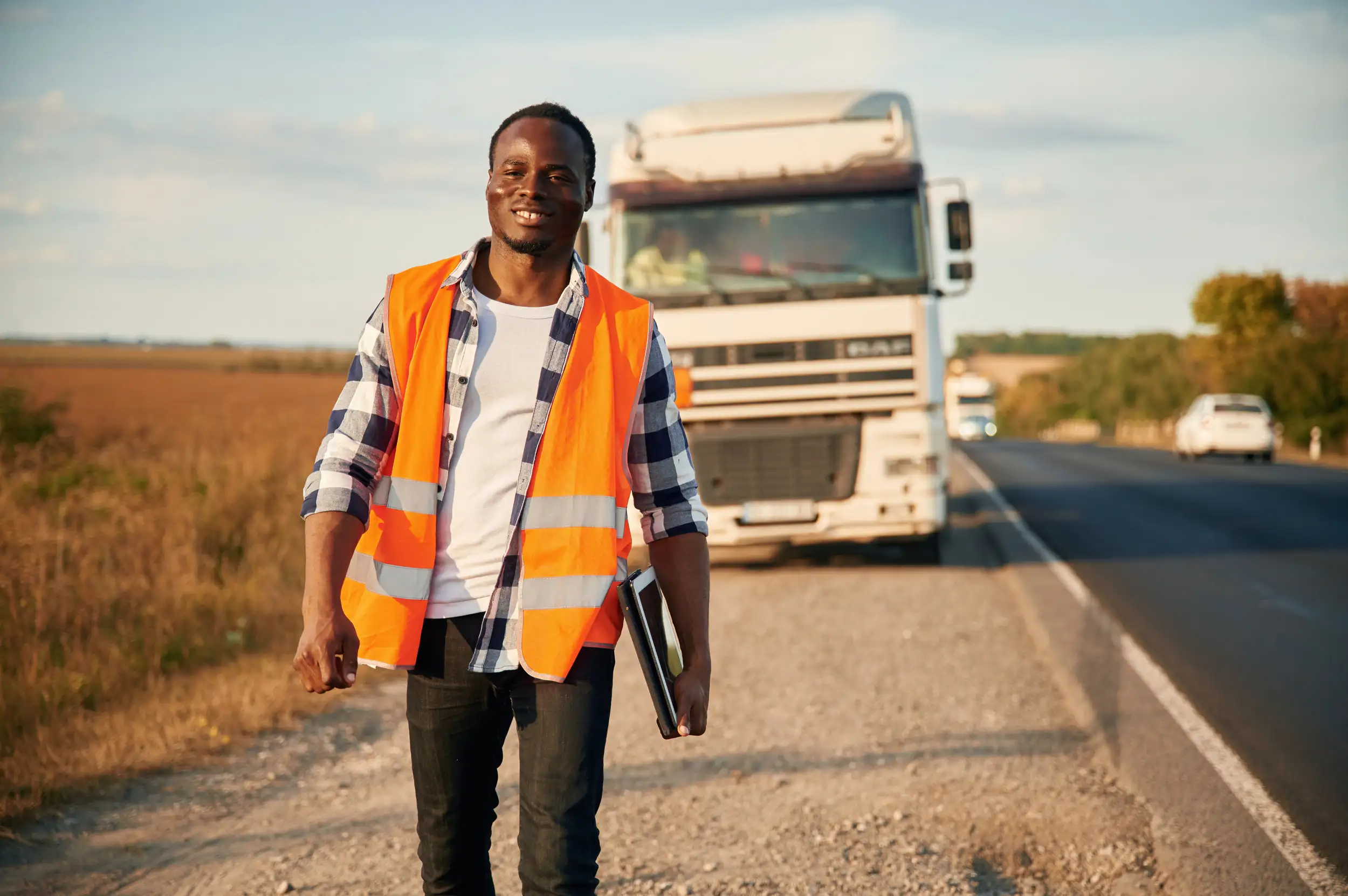 A black walking forward with a truck at the back for road assistance