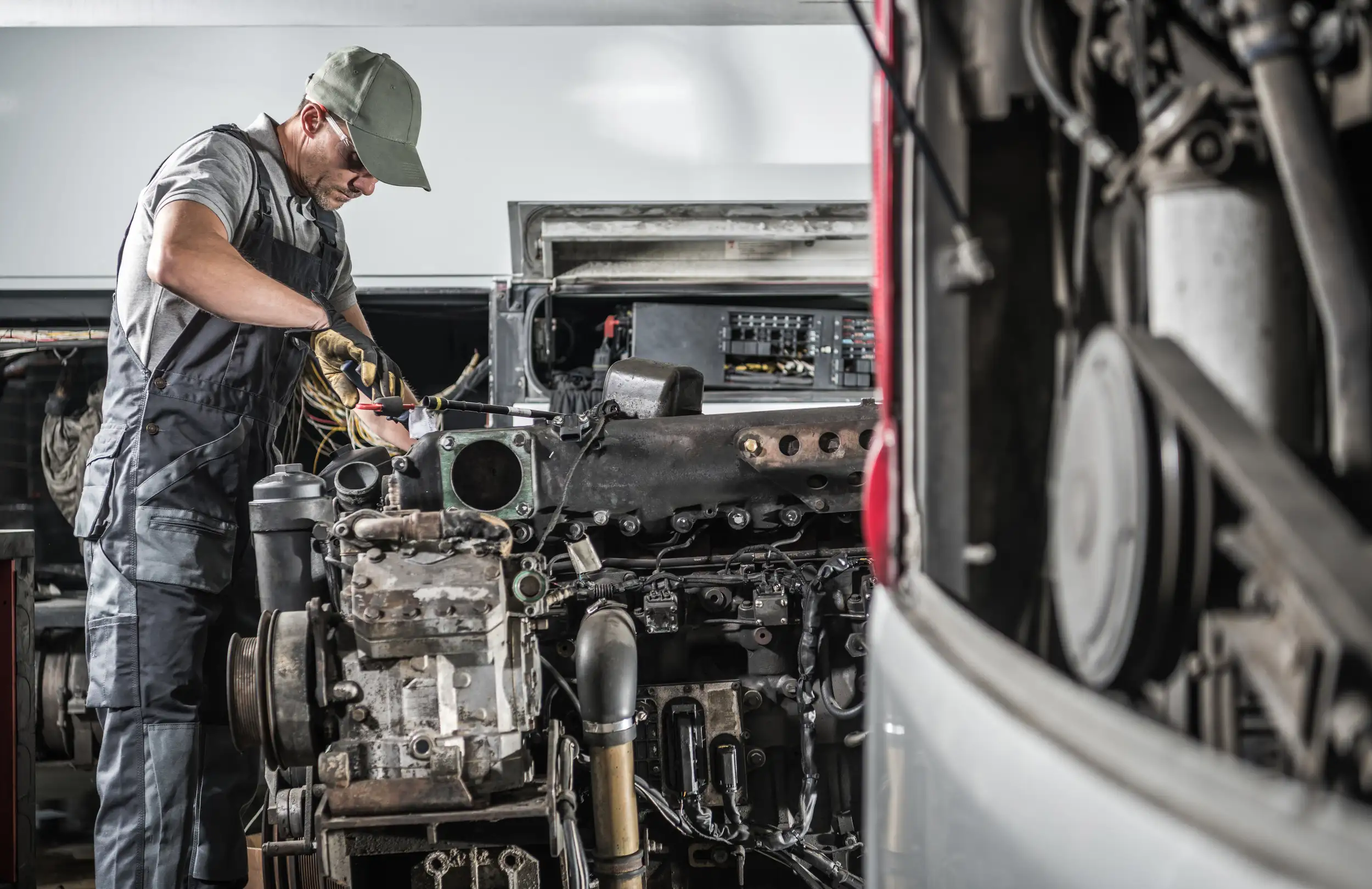 an image of a mechanic fixing the engine of the a truck