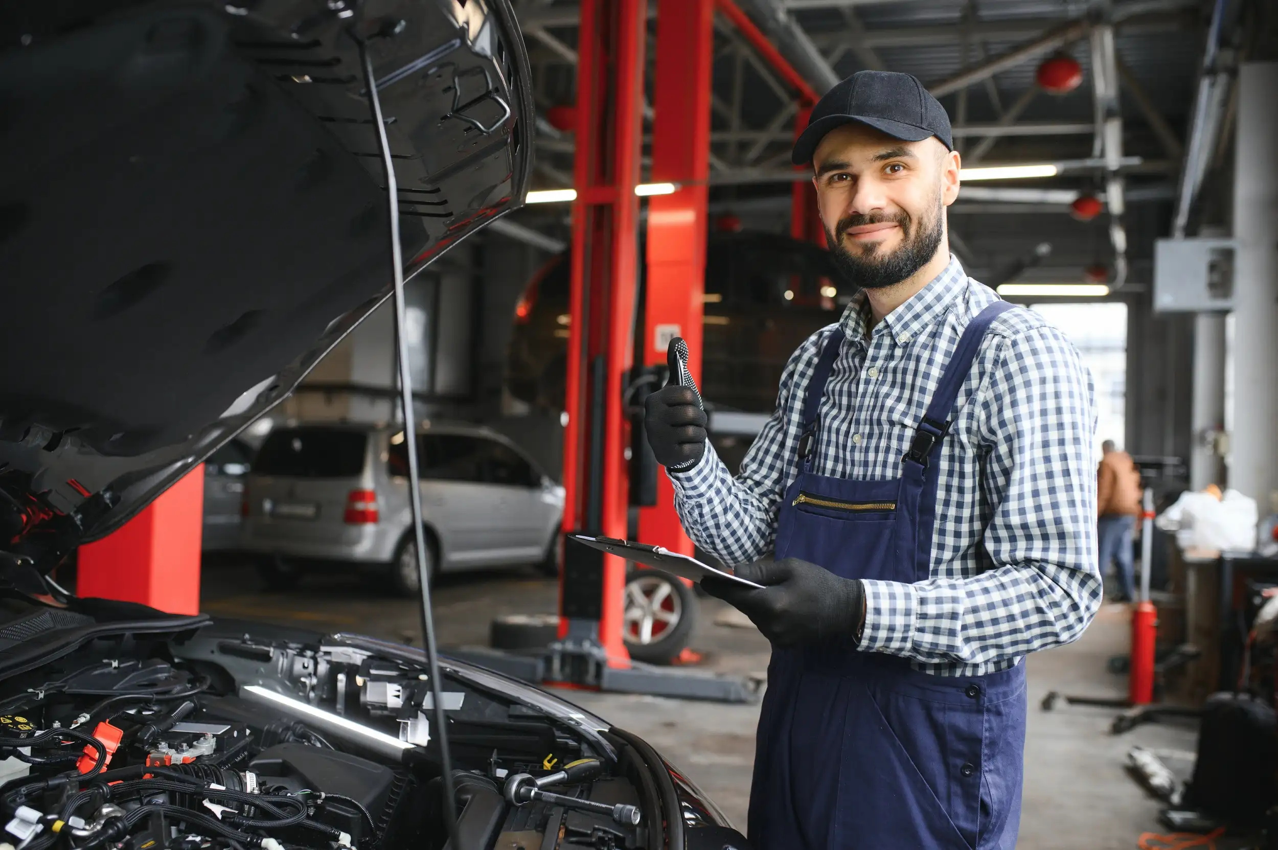 A mechanic smiling and giving a thumbs up