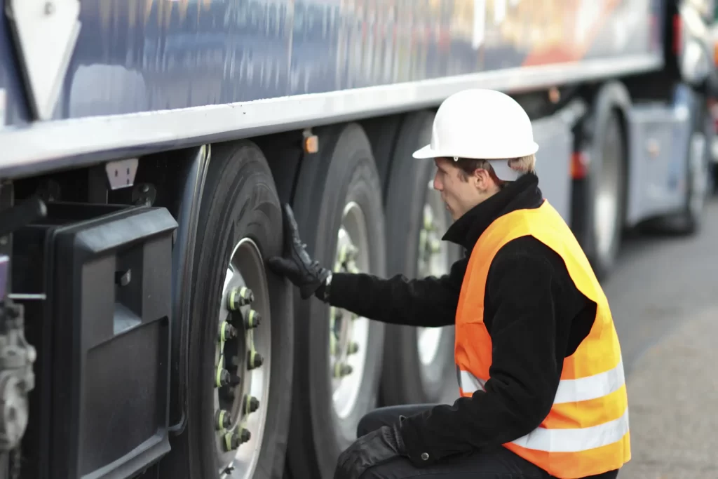 Fleet maintenance with a mechanic checking tire health.