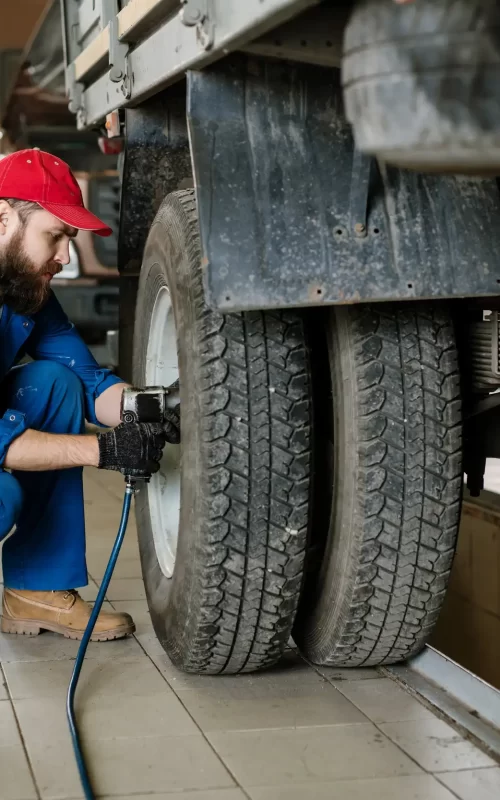 an image of a mechanic adjusting the bolts of the truck