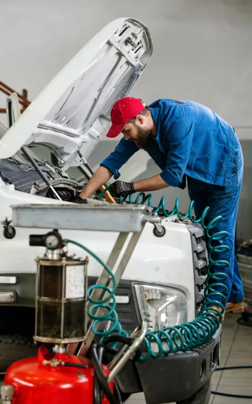 A mechanic using an auto tool device to fix the truck